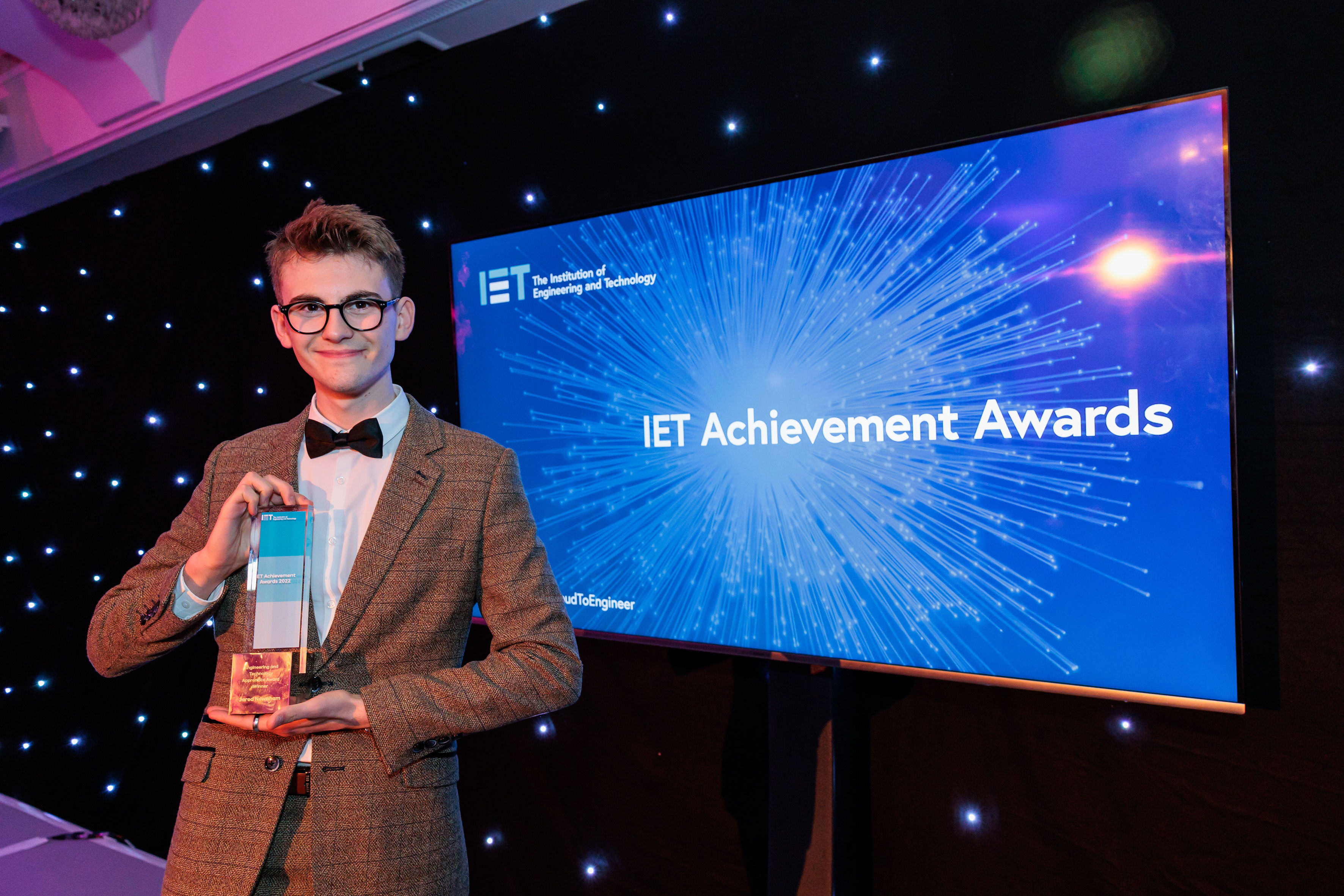 student holds award to the camera