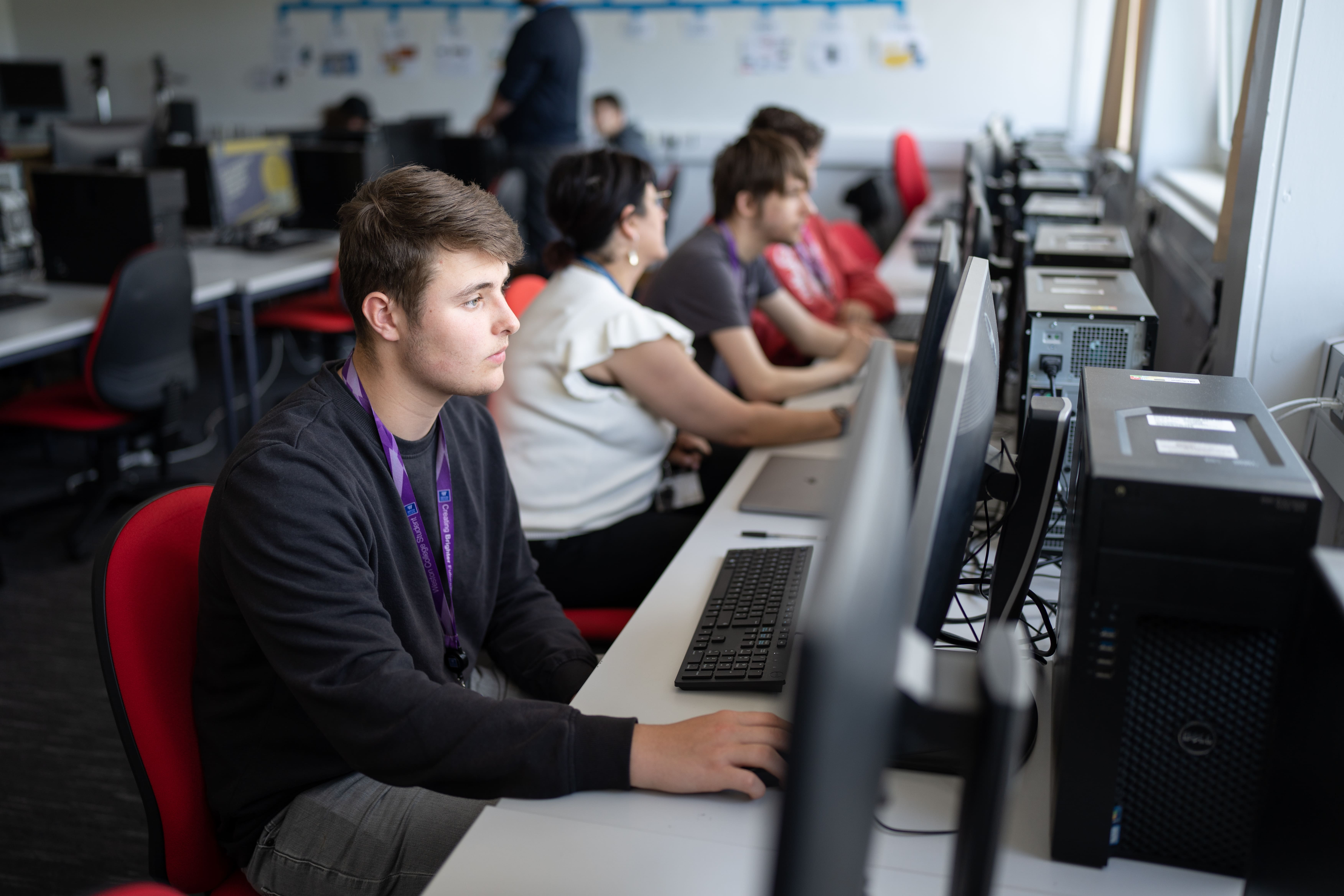 row of students on computers in a classroom