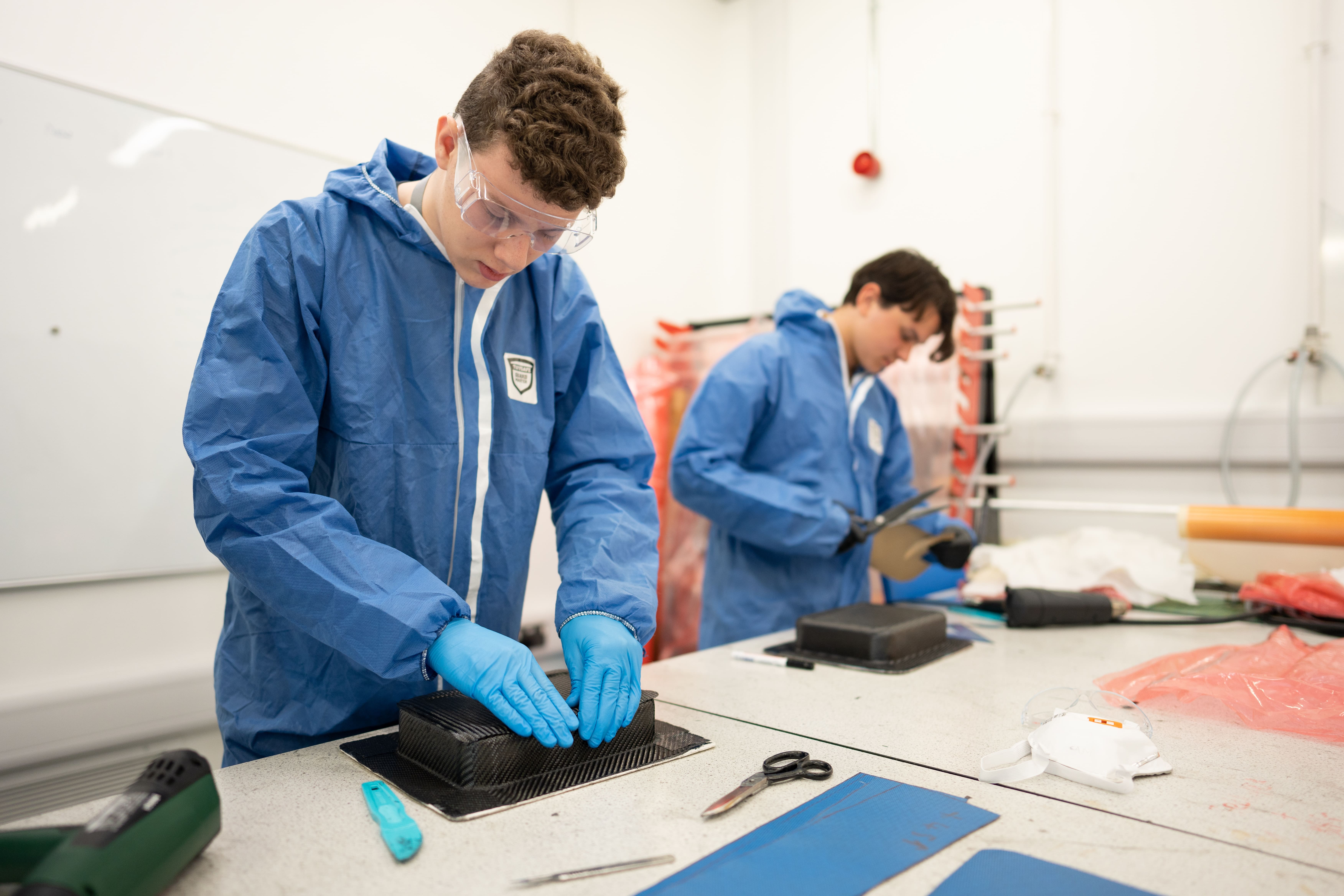students in body suits moulding plastic