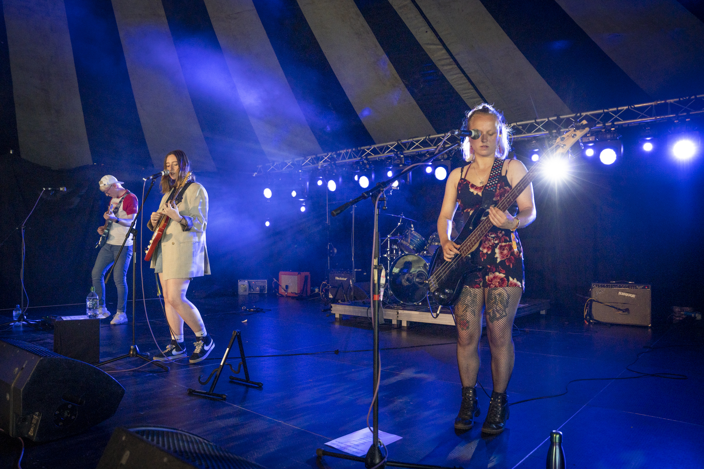 a girl on stage sining and playing a guitar