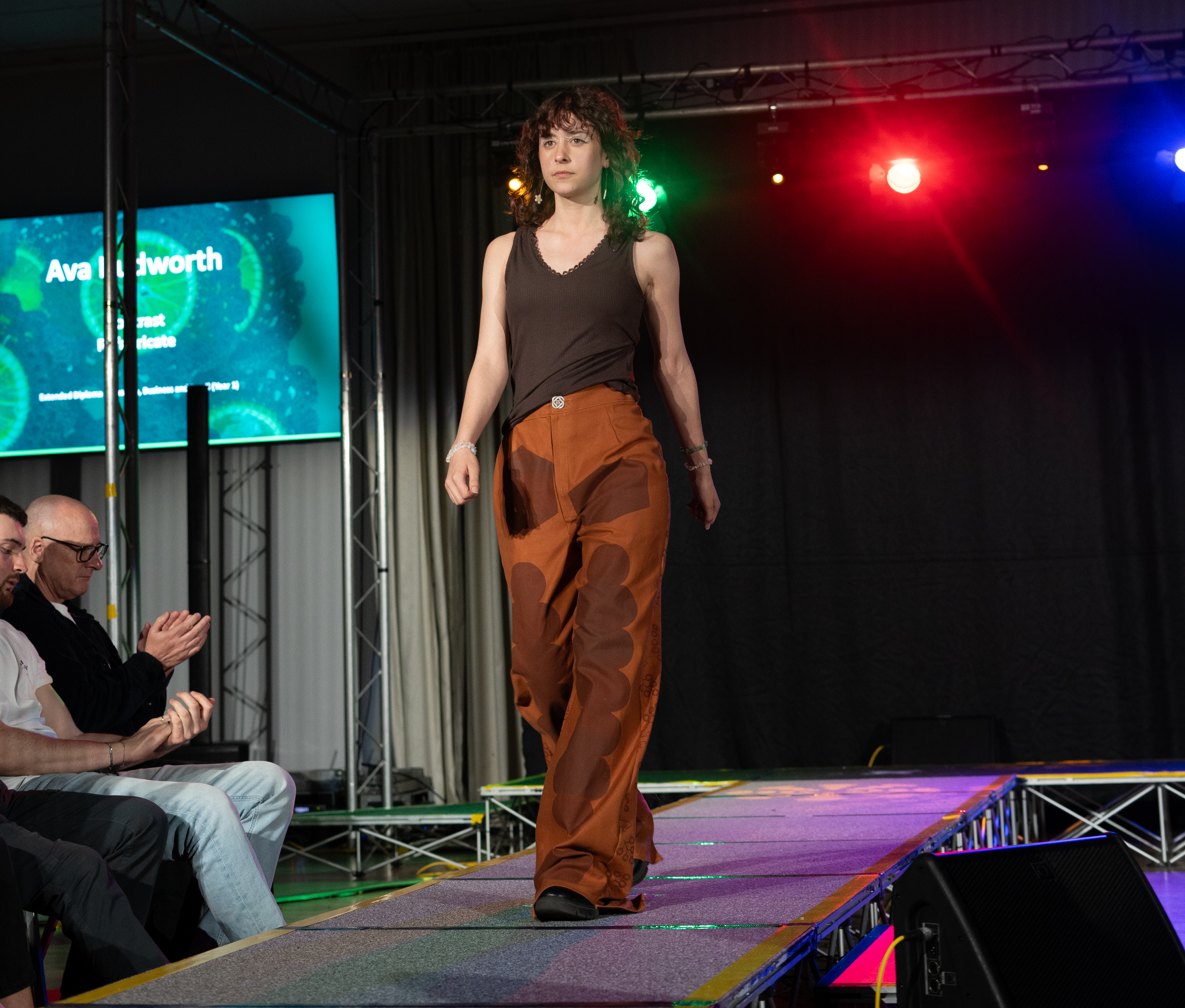 One of our models on the catwalk in orange trousers and brown top