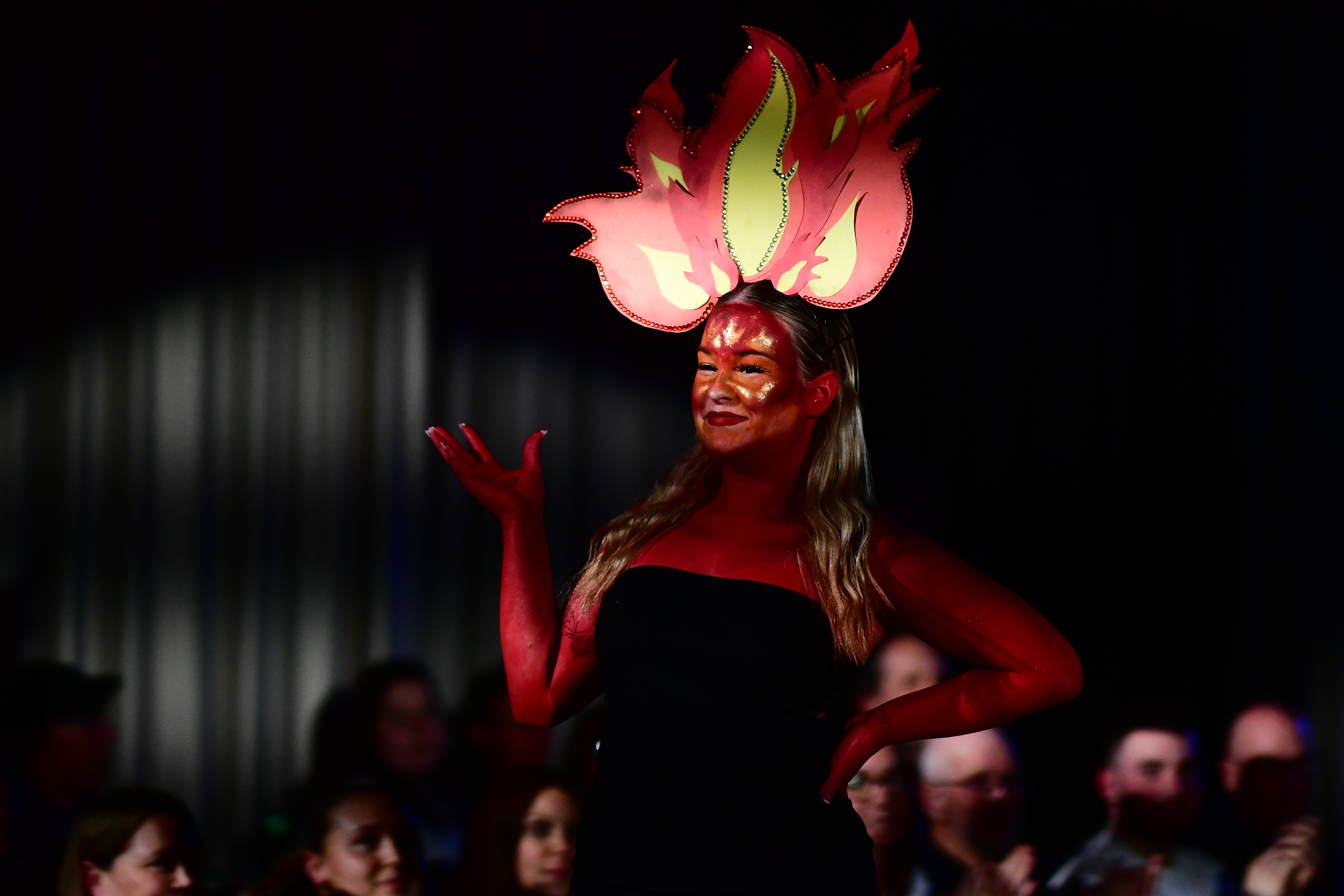 One of the models wearing red body paint and a fire headband