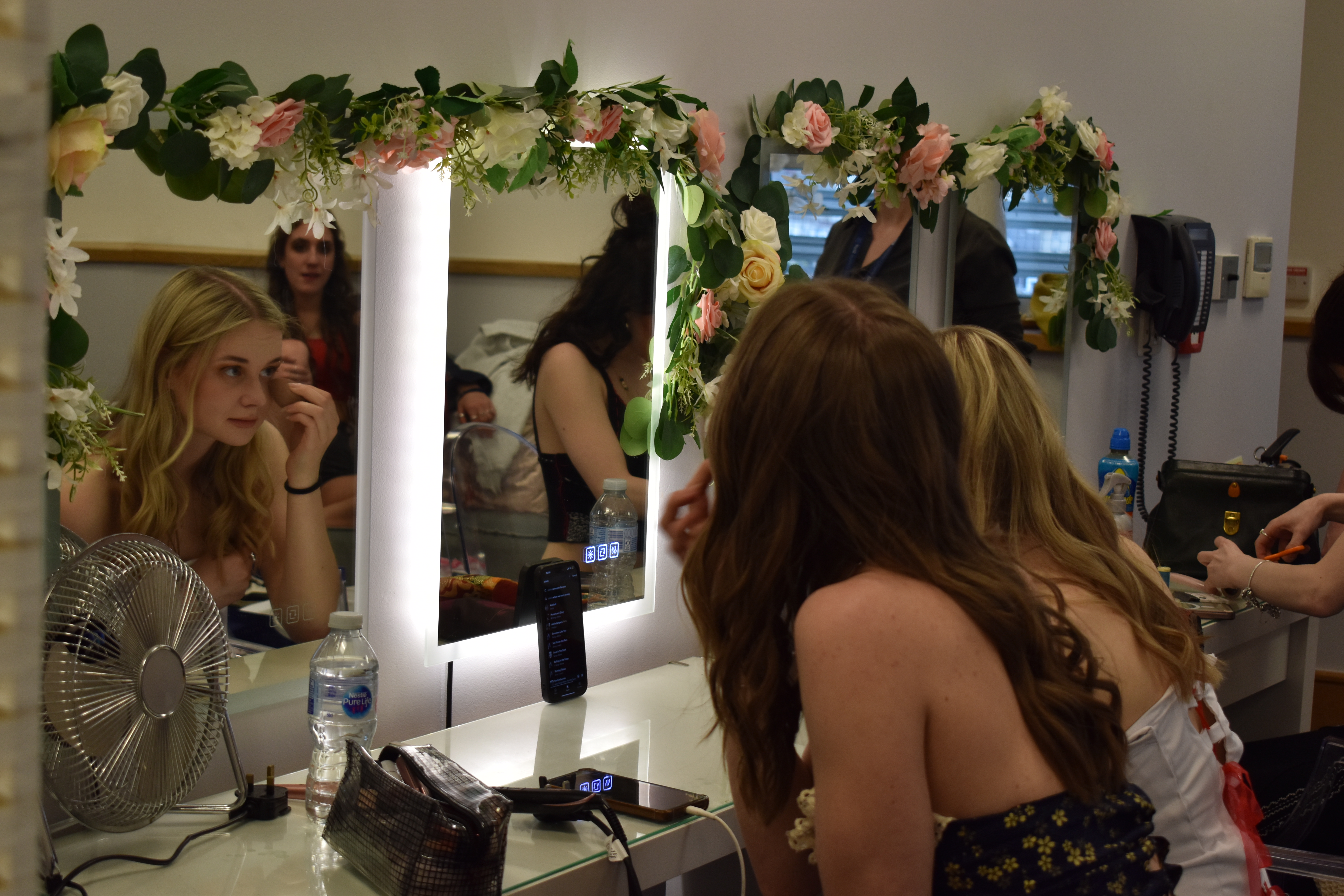 Students doing their makeup in the mirror