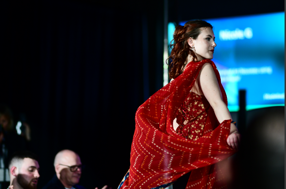 One of the models wearing red garment on the catwalk