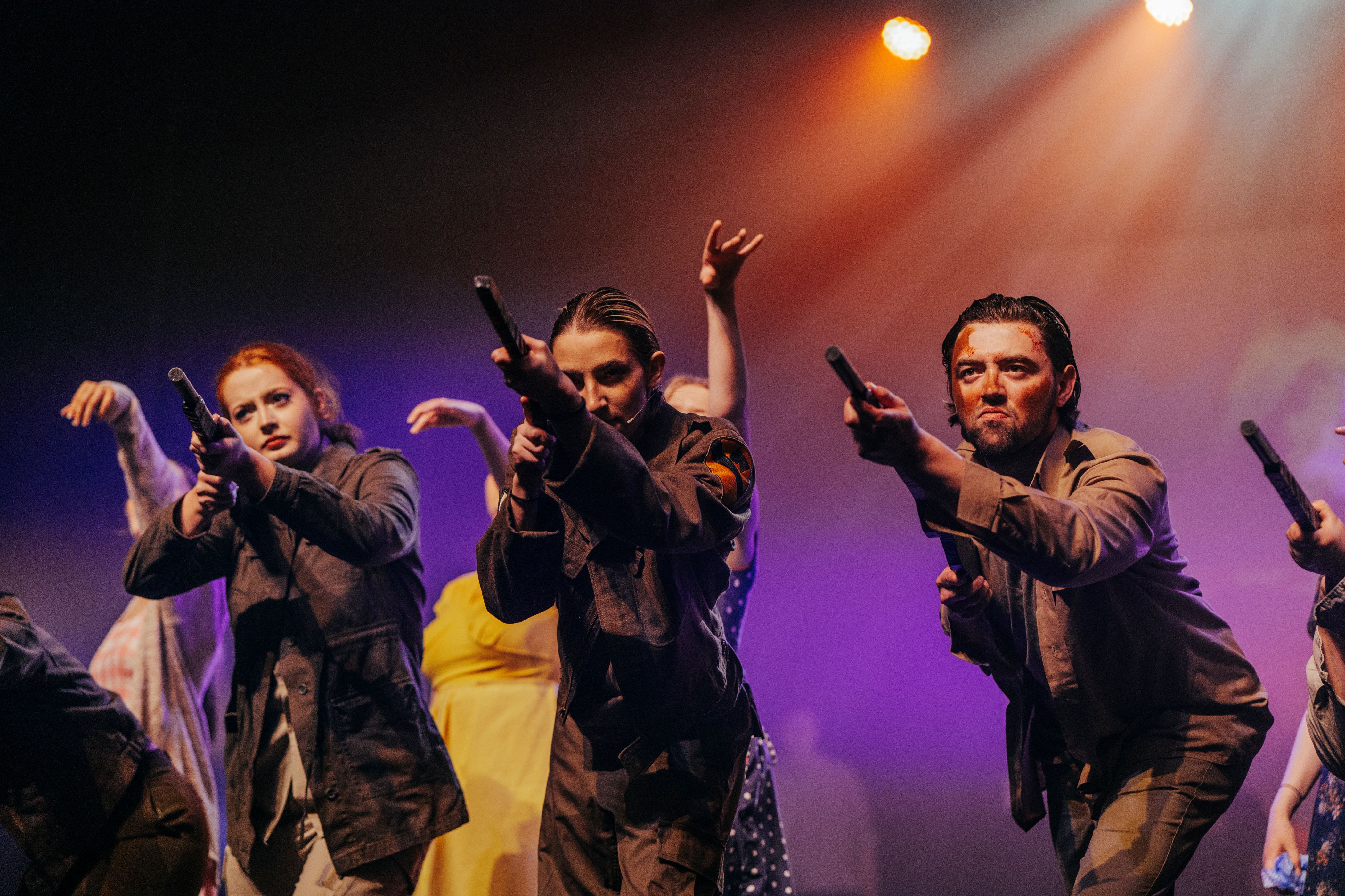 Students pointing fake guns in the army from the dress rehearsal