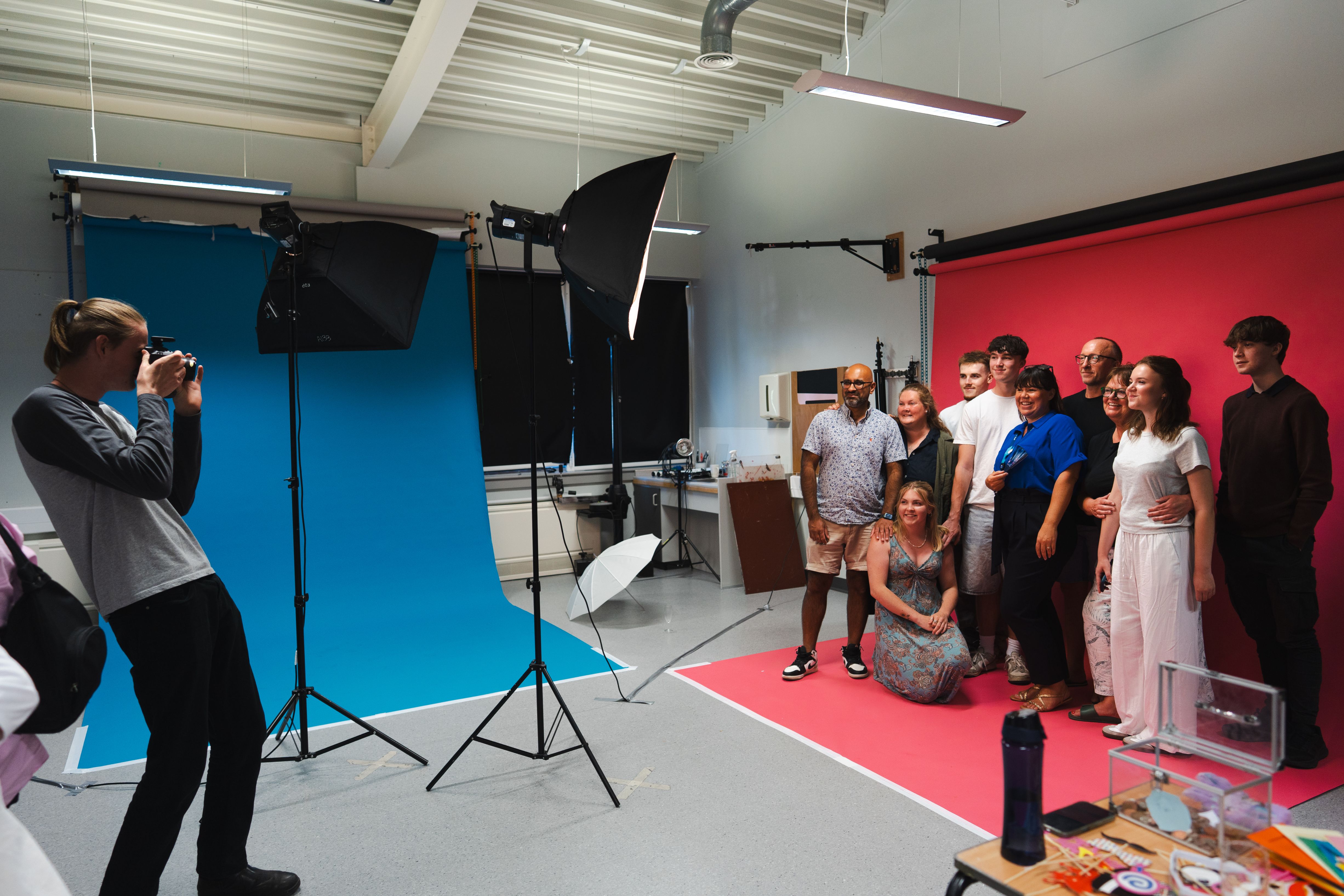 Photography student taking pictures of Media lecturer and family in a photoshoot studio