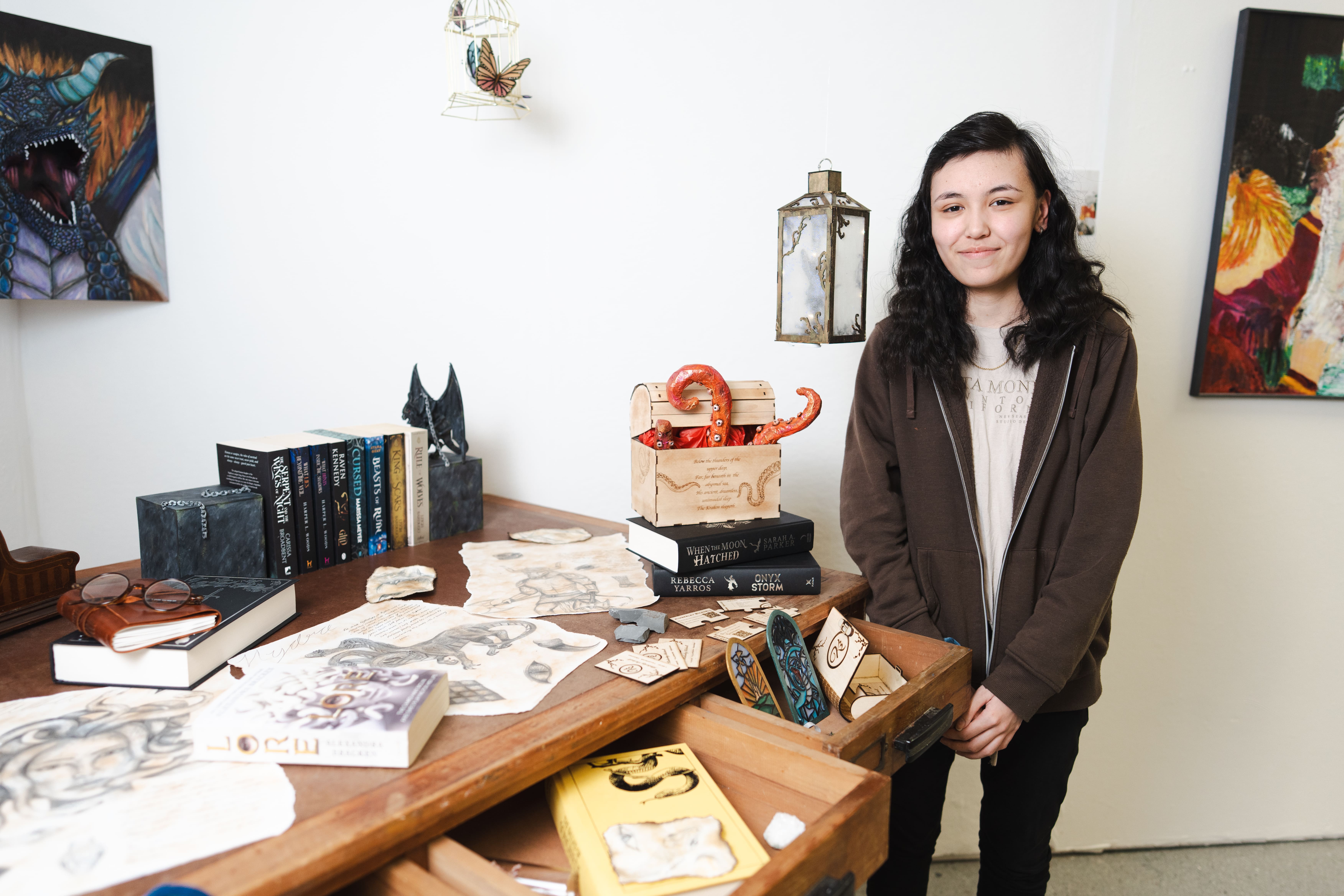 a learner stands next to her octopus emerging from a chest art piece 