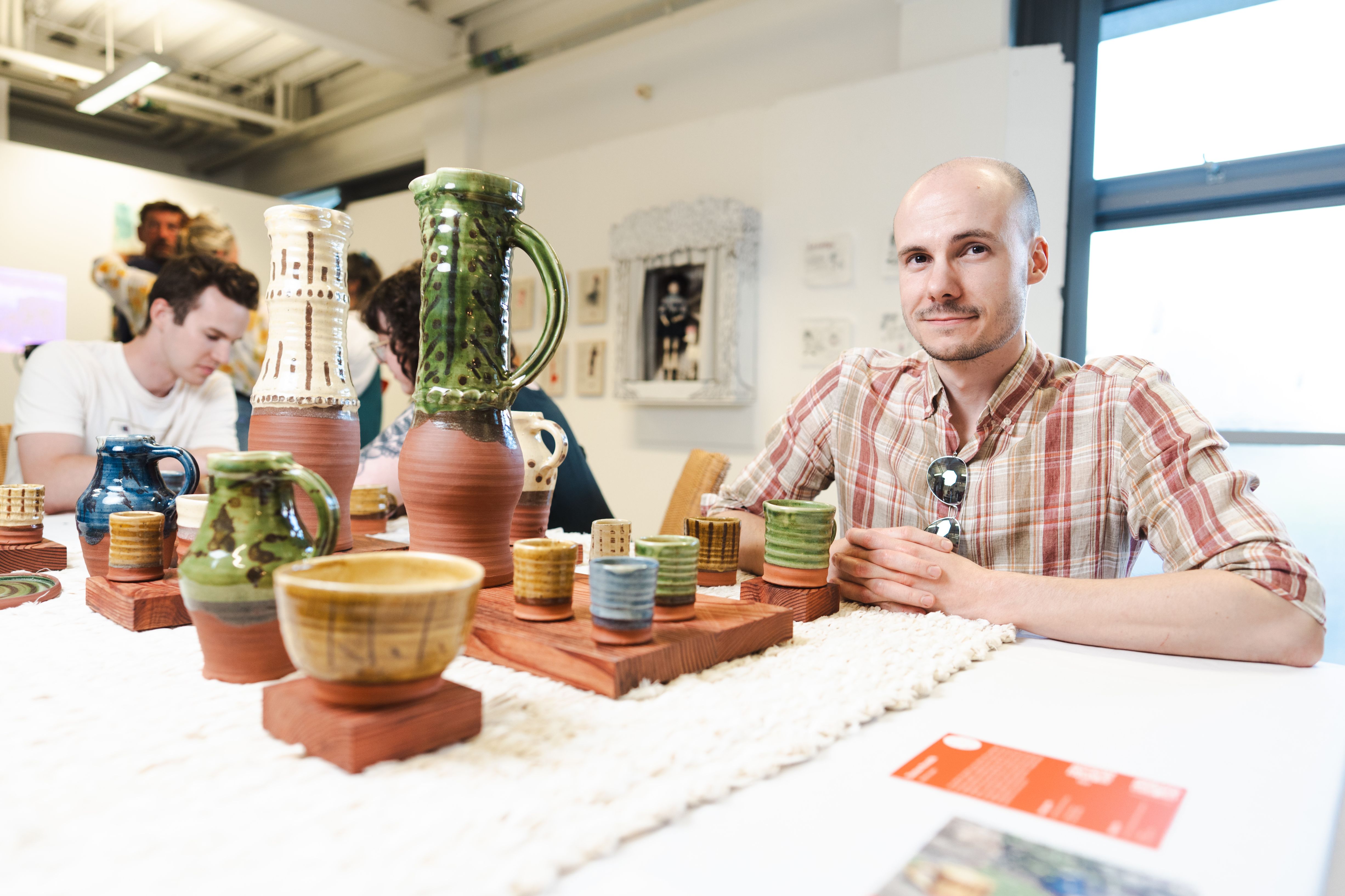 Student sat with his pottery work