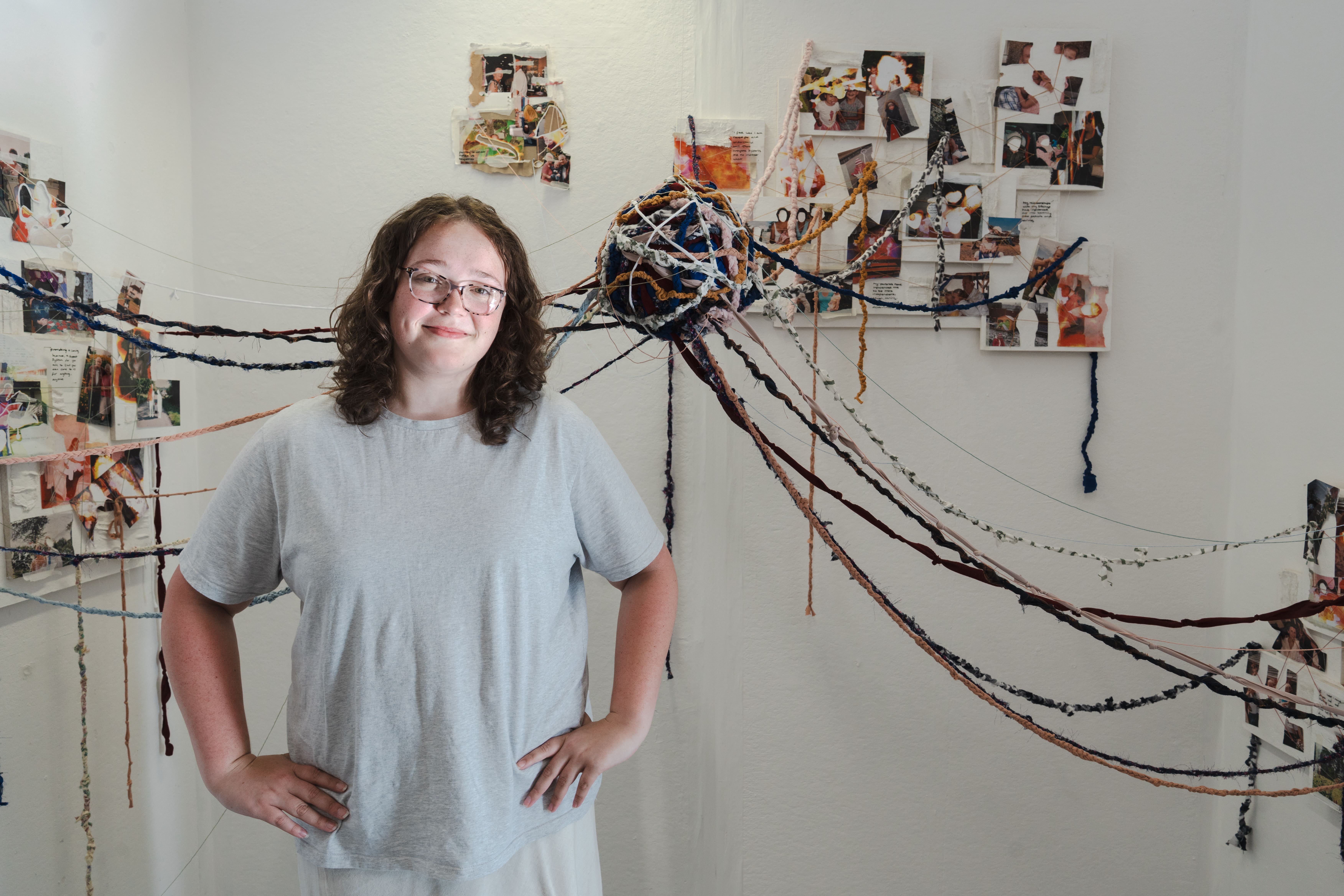 a girl smiling infront of her art