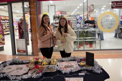 Two learners holding their product