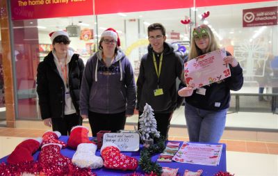 Four learners smiling by Christmas stockings