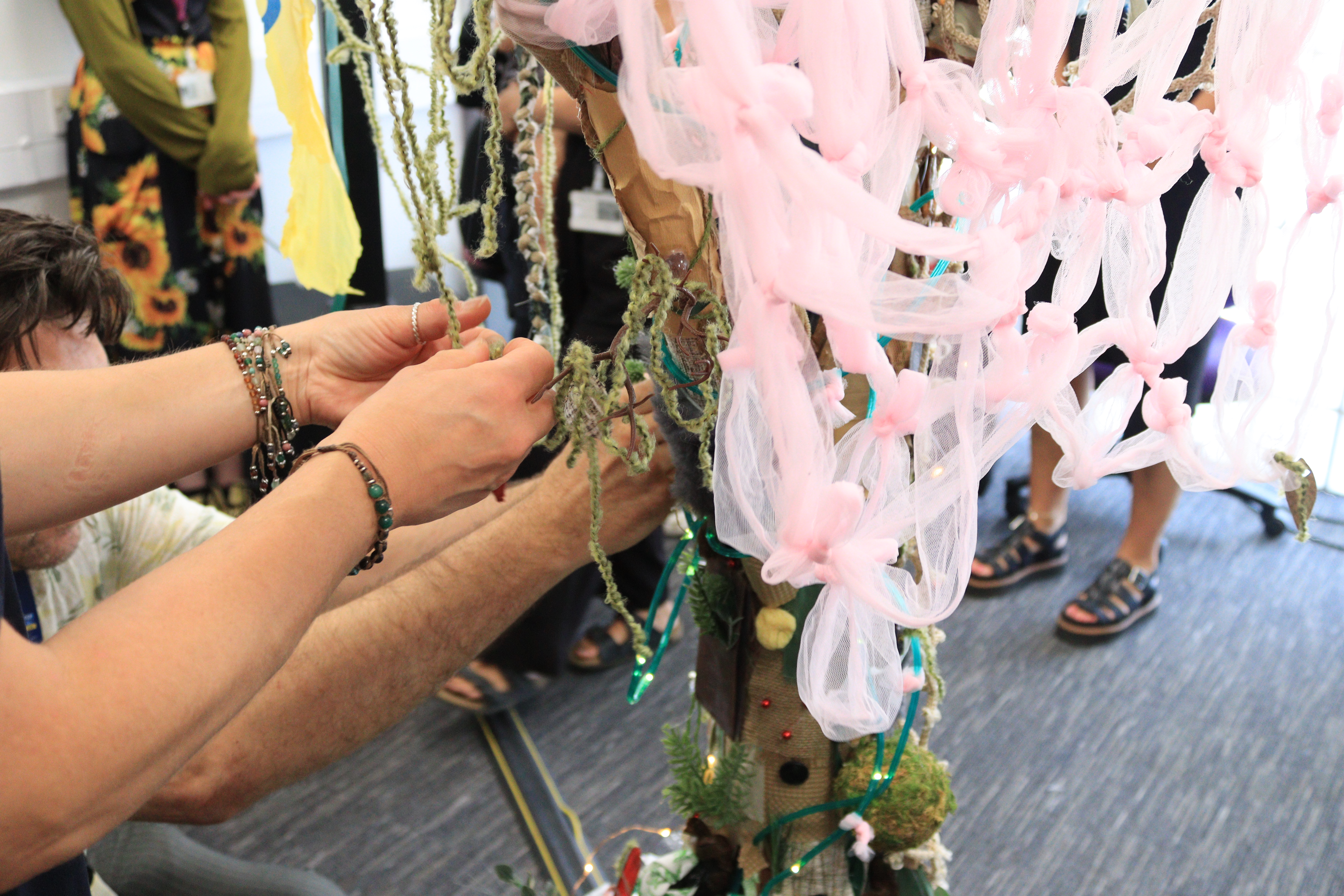 student adding decoration to their art exhibition piece