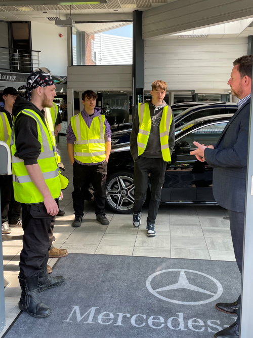 Motor vehicle learners engaging with staff in showroom