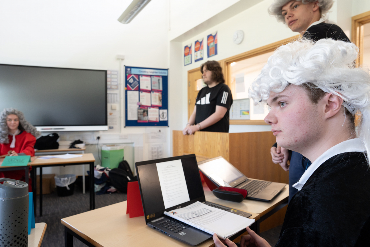 a classroom turned into a courtroom with a student taking the stand