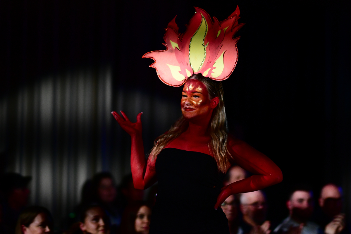 One of the models wearing red body paint and a fire headband 