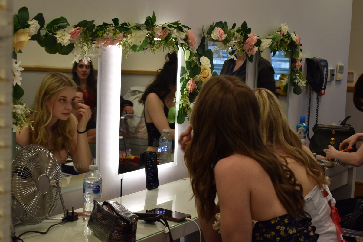 Students doing their makeup in the mirror