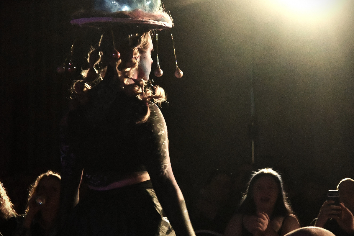 One of the models facing away from the camera wearing galaxy-themed headwear 