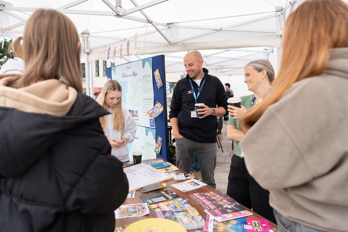 Business and Tourism Staff talking to students in marquee 