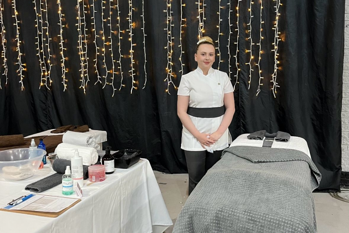 Student standing next to massage bed
