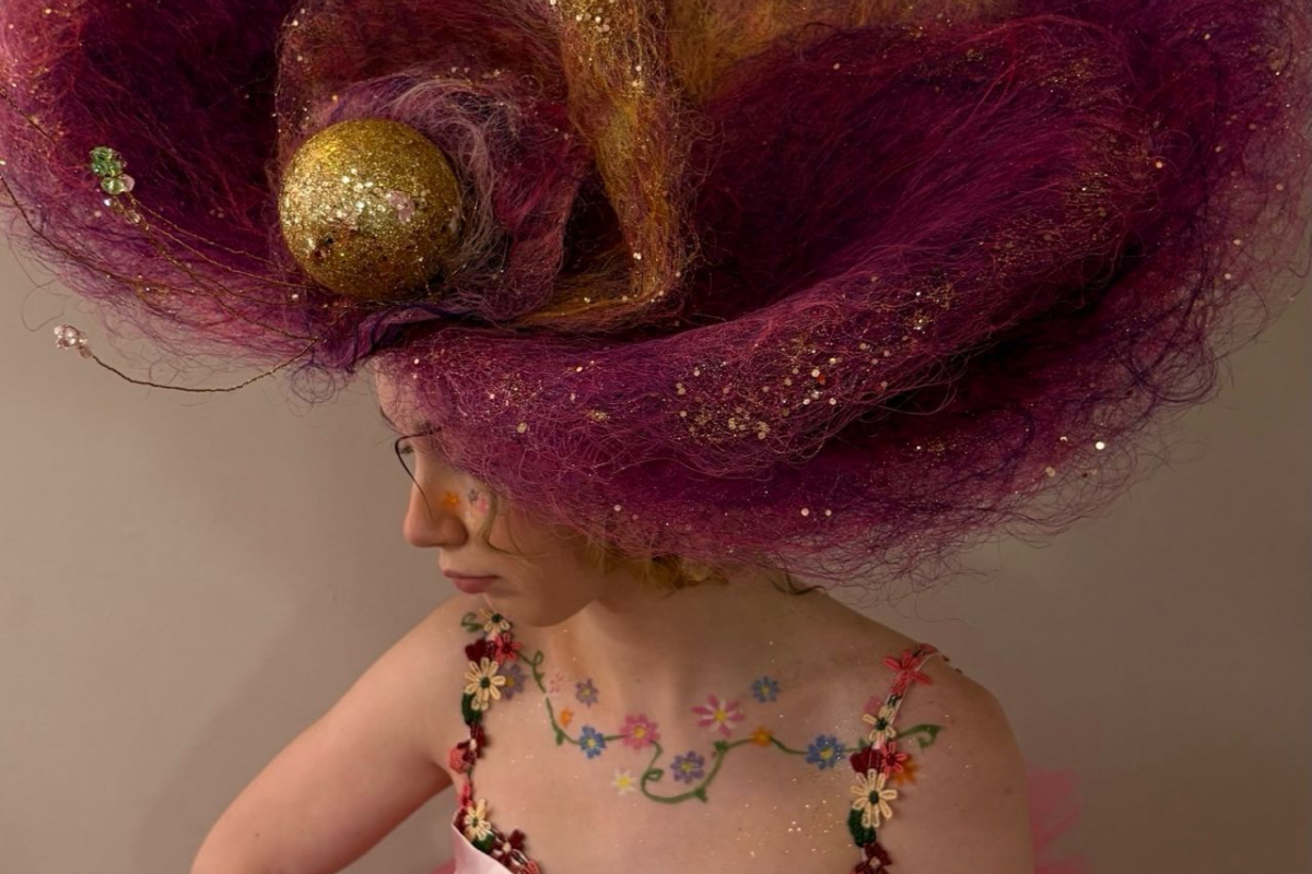 Student with a large felt pink headdress 
