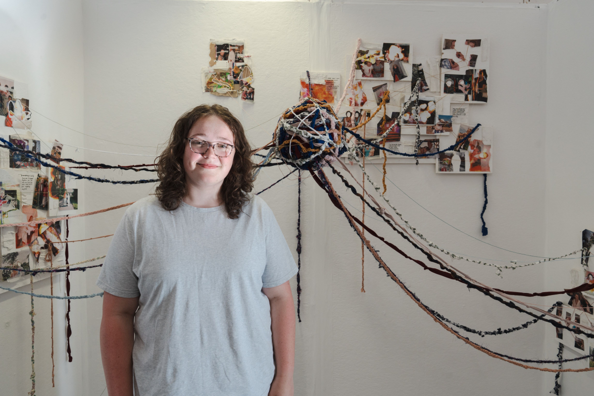 Student standing next to their abstract art 