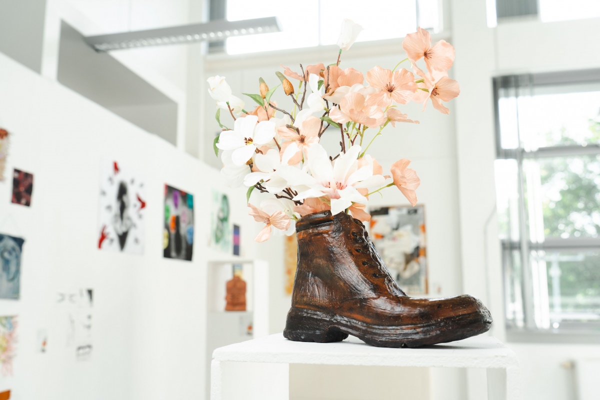 Brown boot acting as a flowerpot with flowers coming out of it 