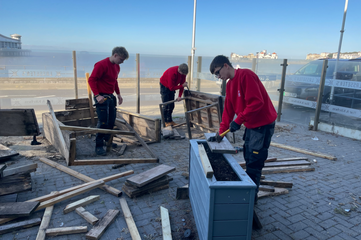 Students disassembling wooden benches