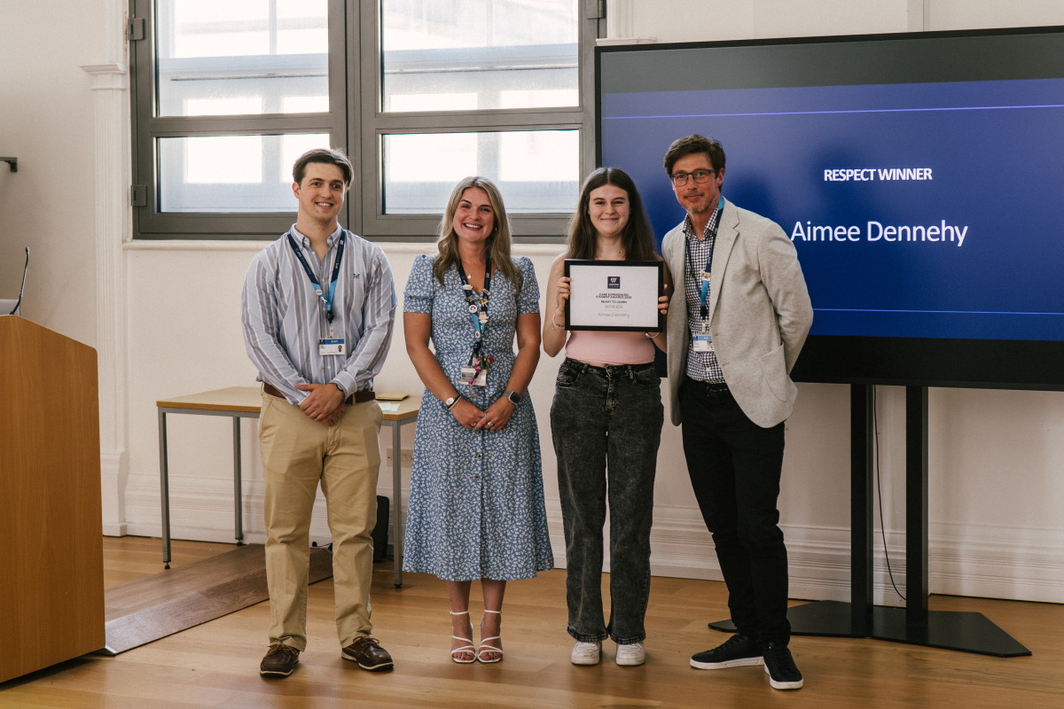 Student Holding Certificate with Staff