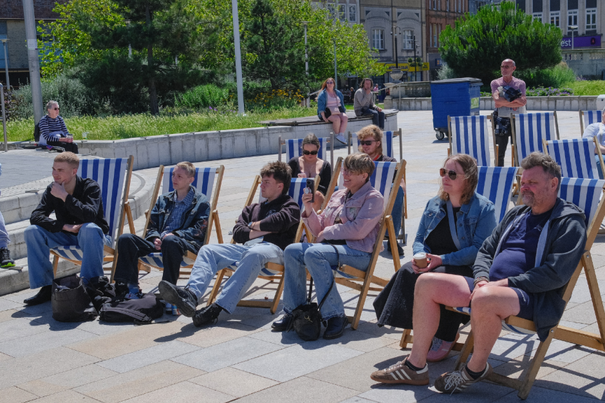 attendees listening to music whilst sitting on deck chairs