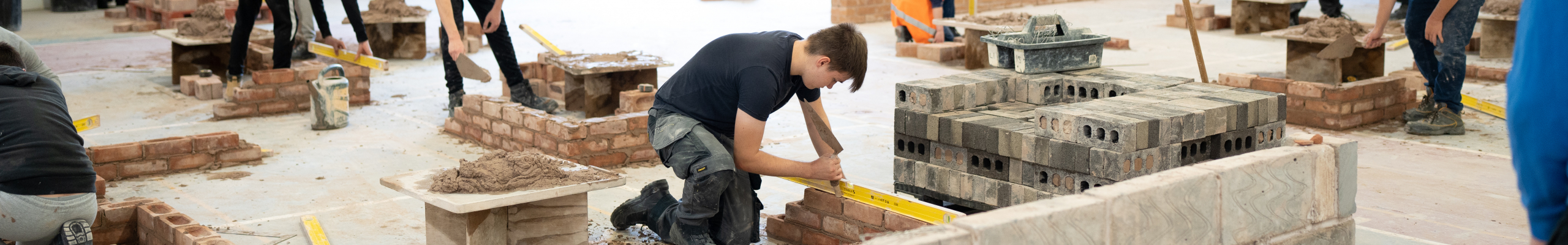 Student buiilding wall out of bricks