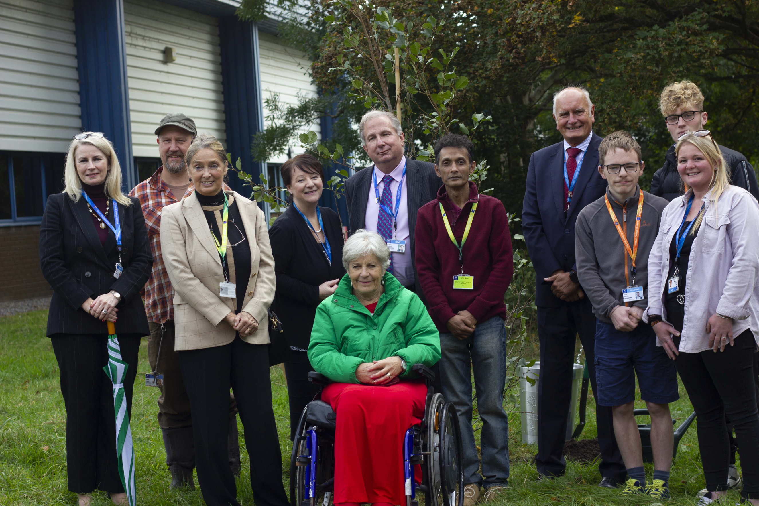 Sir Paul Phillips and the Lord Lieutenant posing in front of Tree of Trees with students and guests of honour