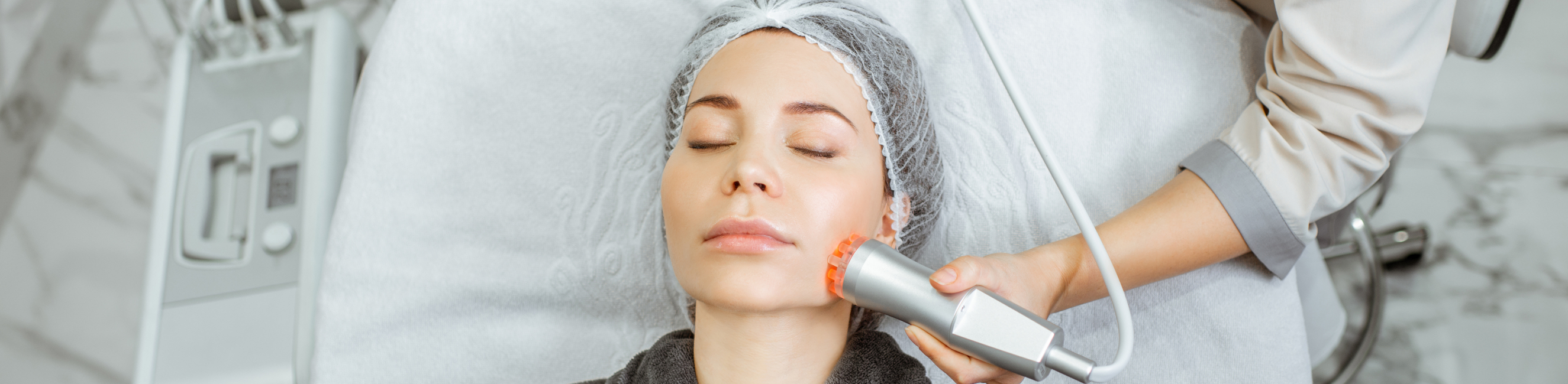 Woman on treatment bed receiving facial treatment