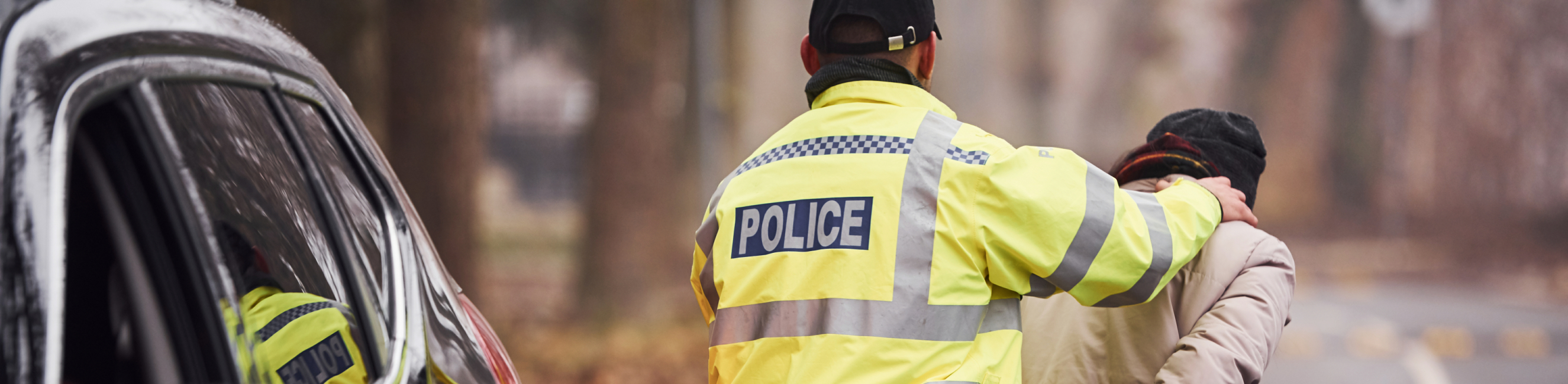 Police Officer arrests man on the road outside of his car