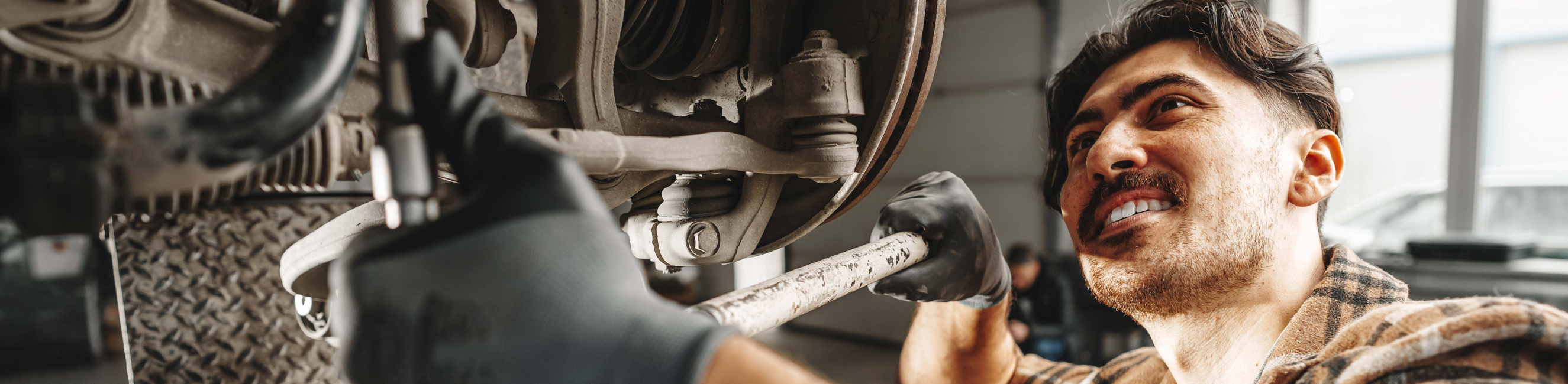 Motor Mechanic using wrench working on car