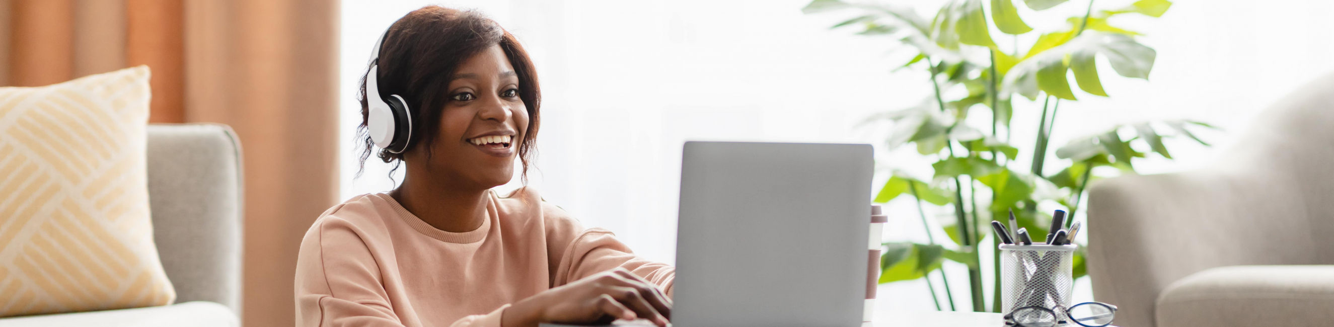 woman using laptop wearing headphones