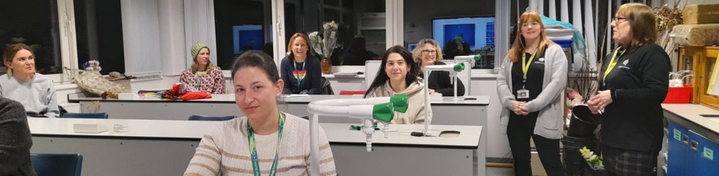 Floristry learners sitting at desks while learning about a floristry industry