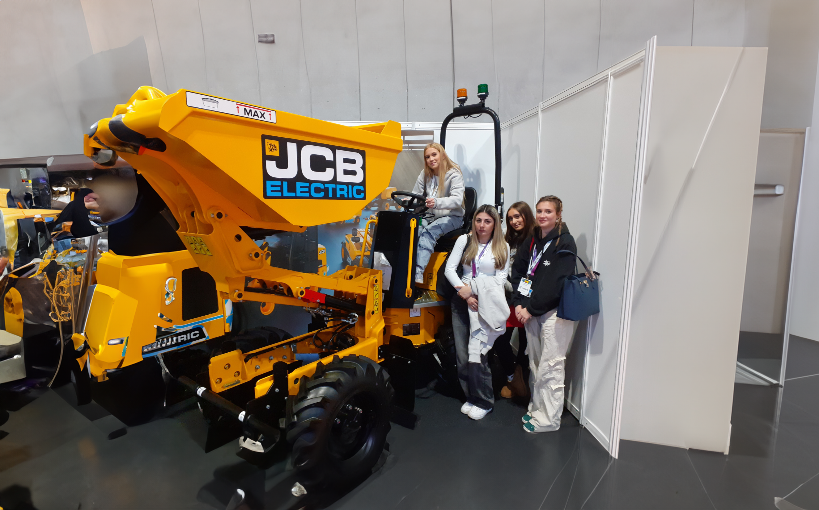 Learners standing around a JCB digger
