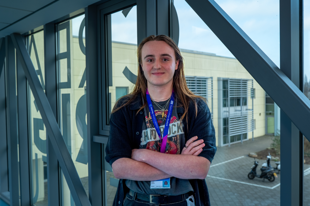 Sixth Form learner, Ryan, standing smiling on the Sixth Form bridge