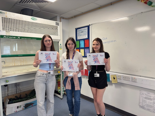 Three students holding their certificates