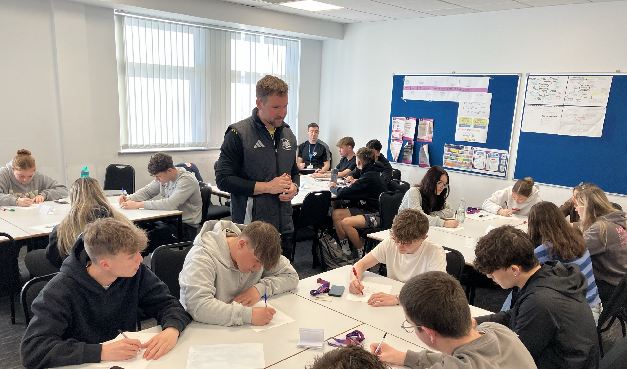 Sport students sat working on task sheets given by Marcus