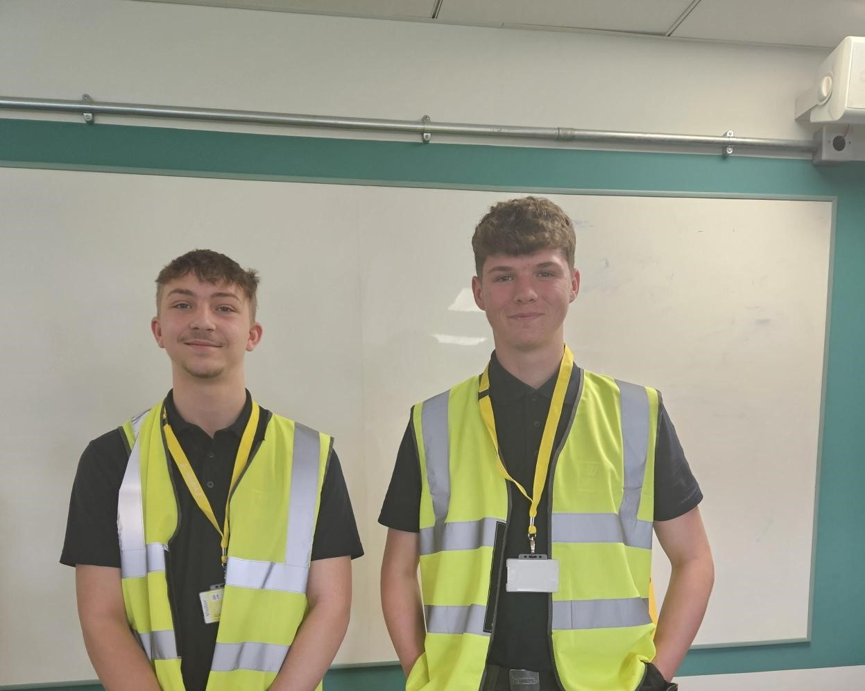 Max and Kieran standing next to each other smiling in their Hi-Vis jackets