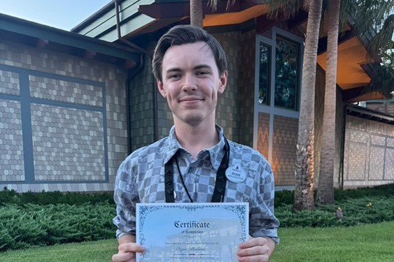 Ryan holding up a certificate whilst smiling