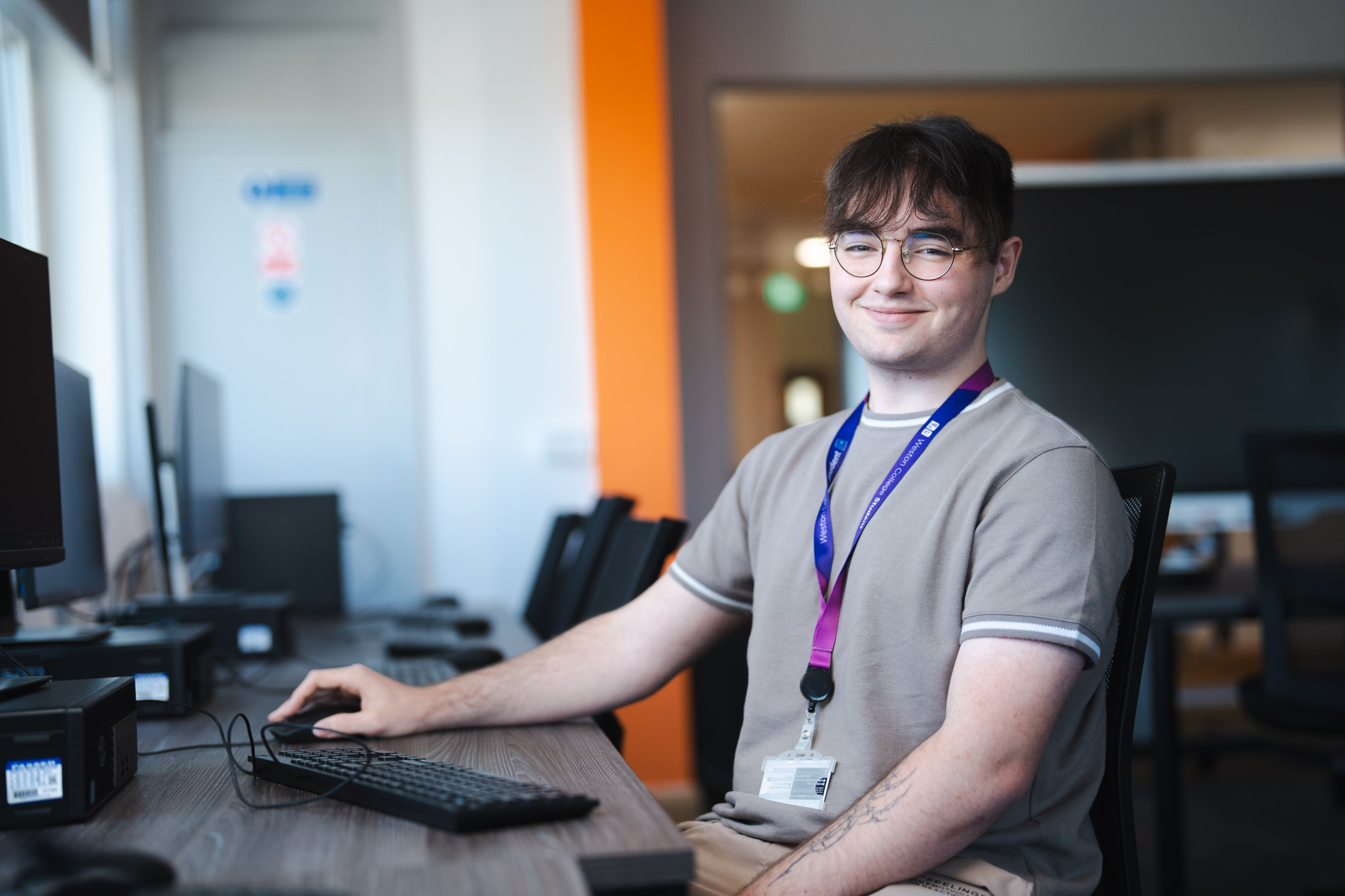 Student sat at a computer smiling