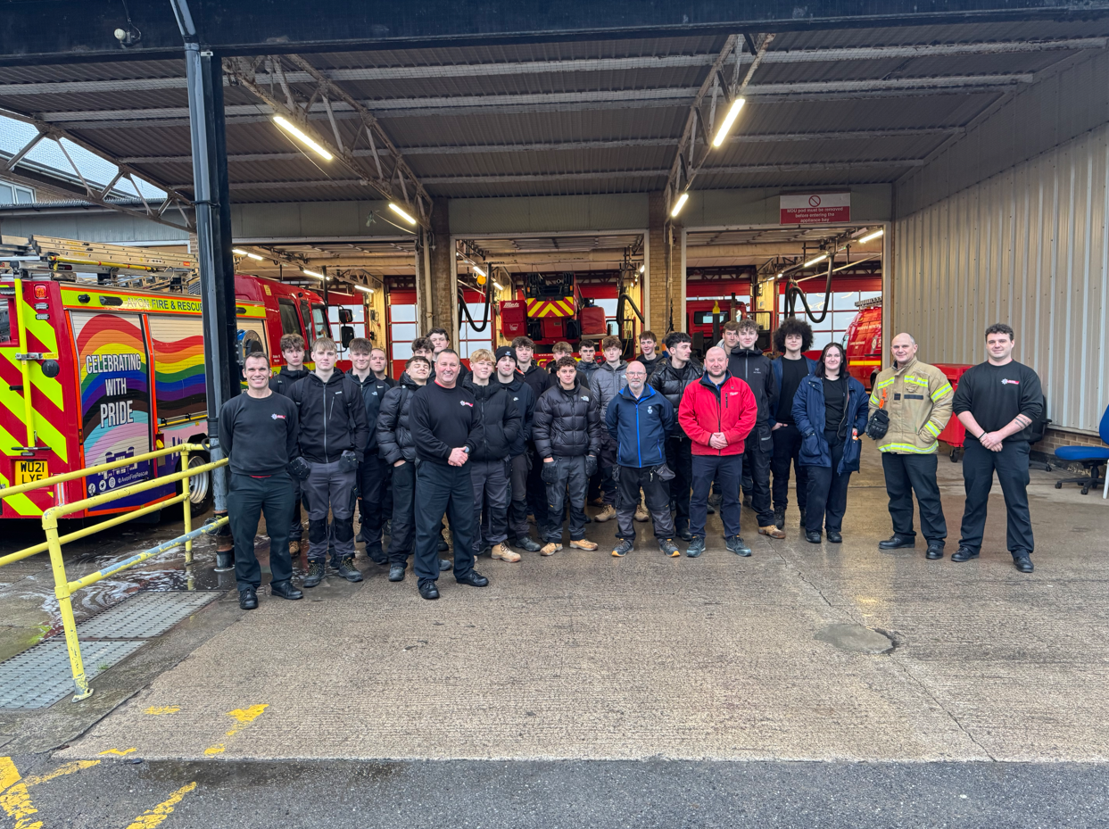 Group photo of electrical students, lecturers, and the firefighters in front of the fire engines