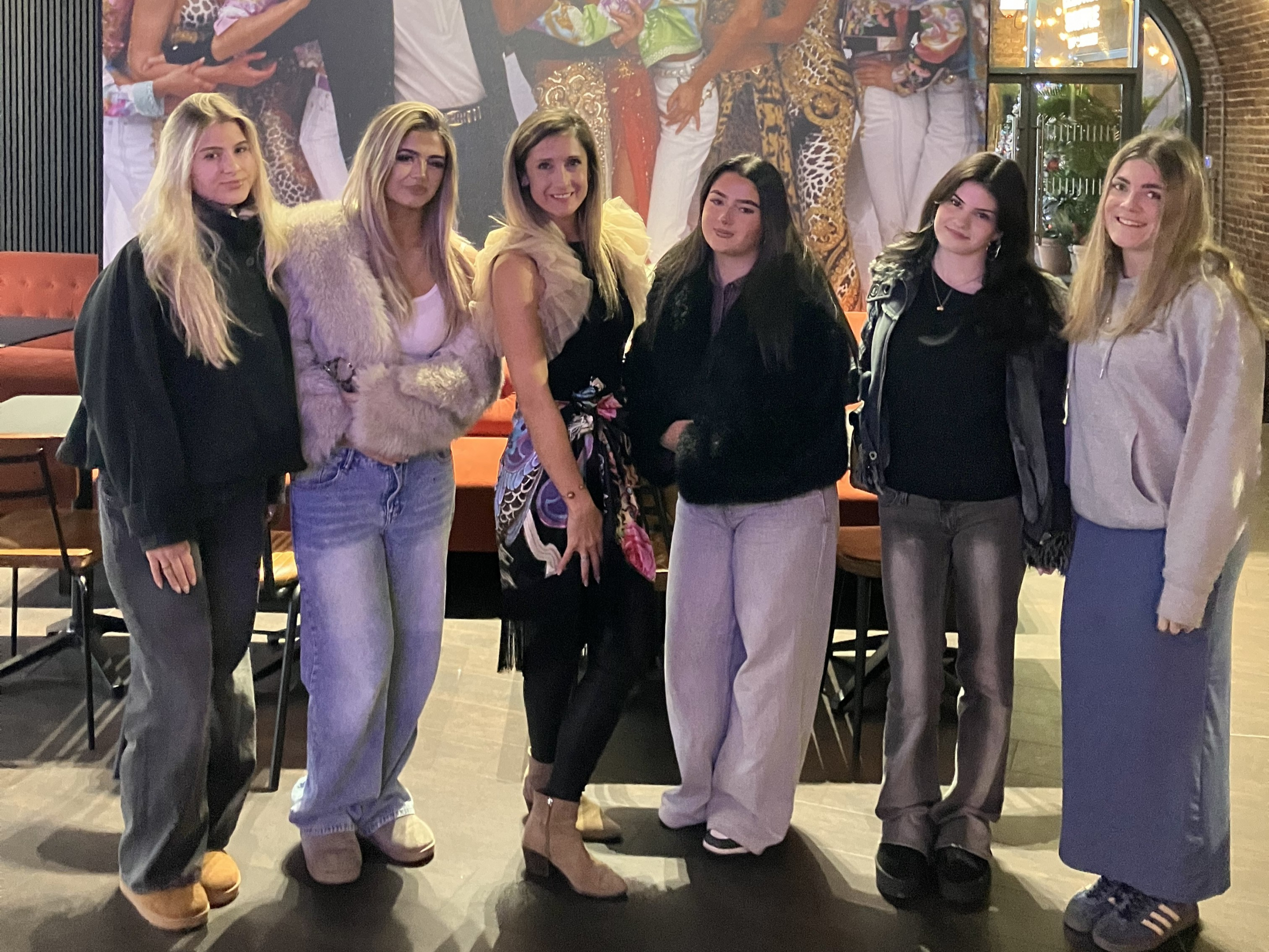 Students and lecturer standing in front of the Versace exhibition