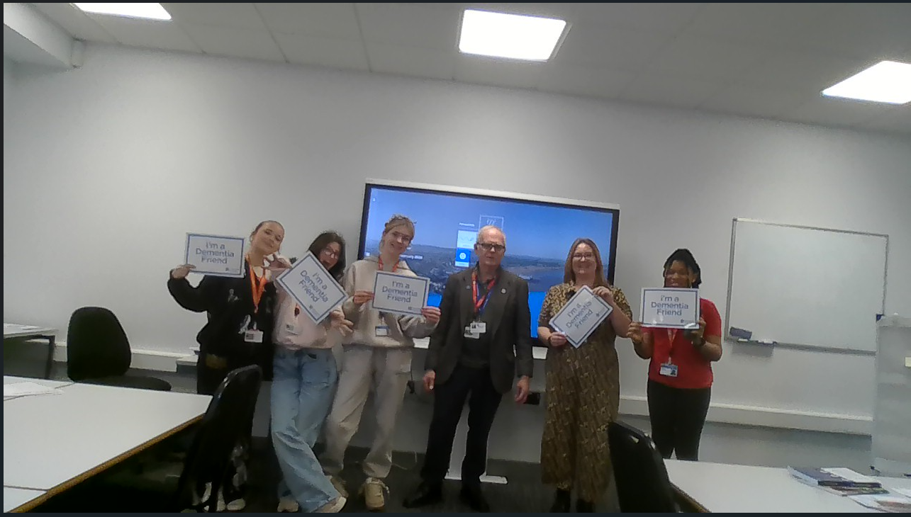 Students holding Dementia Friends signs