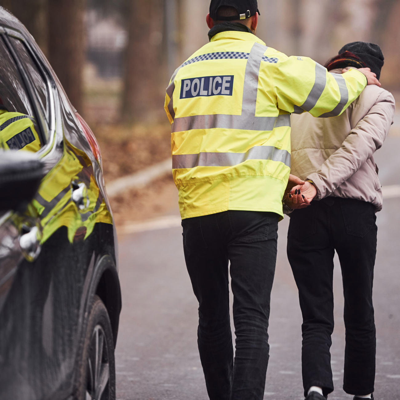 Police Officer arrests man on the road outside of his car
