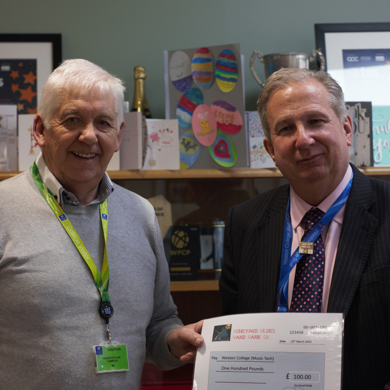 Dr Paul being handed a £100 cheque by Grahame Driver 