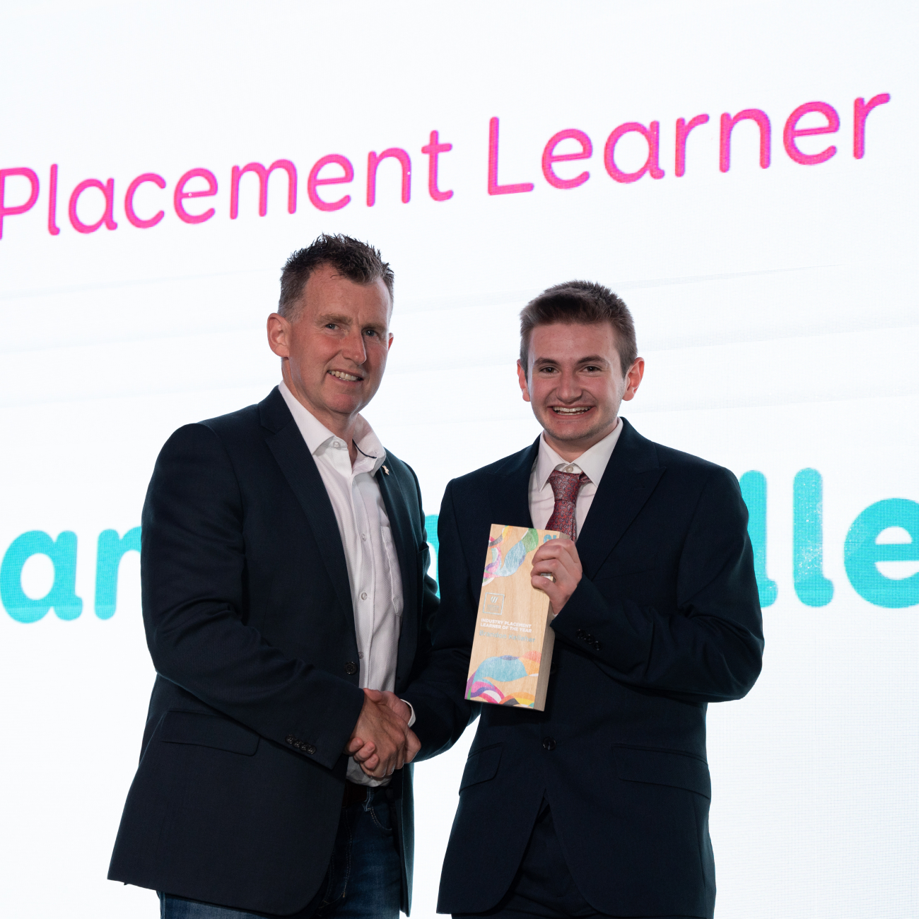 Brandon receiving award while shaking hands