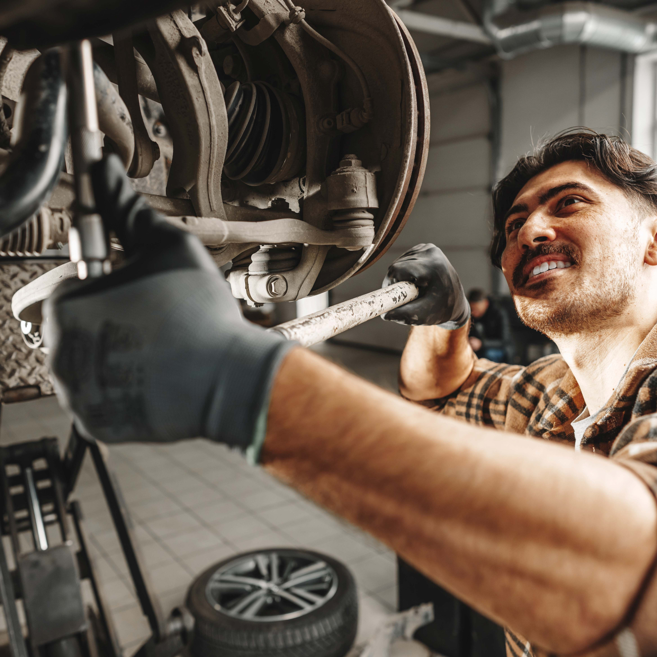 Motor Mechanic using wrench working on car